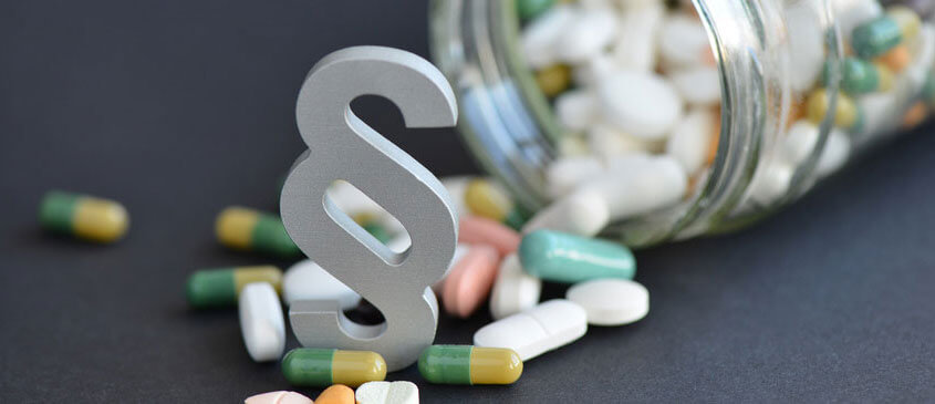 Modell des Paragraphenzeichen zwischen Pillen und Tabletten